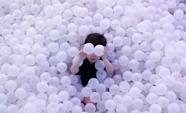 A child plays in a ball pit during an immersive exhibit at the Megapolis Outlets Center in Panama City, Tuesday, April 7, 2026. (AP Photo/Matias Delacroix)