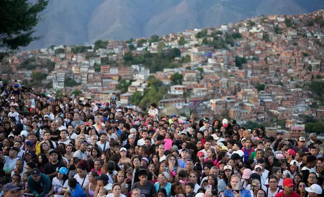 Faithful gather to watch a Way of the Cross reenactment as part of Holy Week celebrations in the Petare neighborhood of Caracas, Venezuela, Friday, April 3, 2026. (AP Photo/Ariana Cubillos)