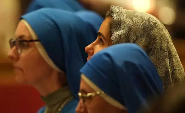 A faithful attends Pope Leo XIV's Easter Vigil inside St. Peter's Basilica at The Vatican, Saturday, April 4, 2026. (AP Photo/Andrew Medichini)