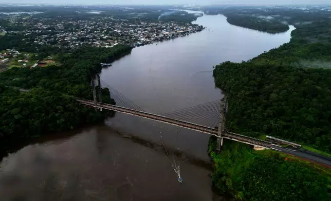 View of the Franco-Brazilian Binational Bridge, over the Oiapoque River, connecting the city of Oiapoque, in the background, with French Guiana, during sunrise in the city of Oiapoque, Amapa state, Brazil, Tuesday, March 10, 2026. (AP Photo/Eraldo Peres)