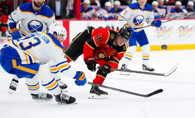 Ottawa Senators' Tim Stutzle (18) passes the puck around Buffalo Sabres' Mattias Samuelsson (23) during the second period of an NHL hockey game in Ottawa on Thursday, April 2, 2026. (Sean Kilpatrick/The Canadian Press via AP)