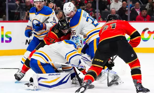 Buffalo Sabres goaltender Ukko-Pekka Luukkonen, bottom left, covers the puck as teammate Rasmus Dahlin (26) tries to push away Ottawa Senators' Michael Amadio (22) during second-period NHL hockey game action in Ottawa, Ontario, Thursday, April 2, 2026. (Sean Kilpatrick/The Canadian Press via AP)