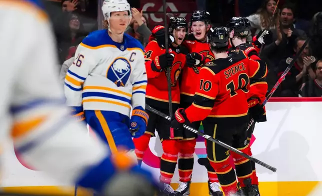 Ottawa Senators' Dylan Cozens, third from right, celebrates with teammates after scoring as Buffalo Sabres' Rasmus Dahlin (26) skates past during second-period NHL hockey game action in Ottawa, Ontario, Thursday, April 2, 2026. (Sean Kilpatrick/The Canadian Press via AP)