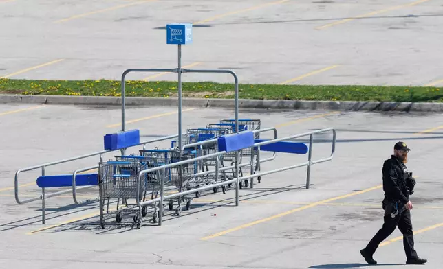 Omaha police work outside a Walmart store at South 72nd and Pine Streets in Omaha, Neb., on Tuesday, April 14, 2026, after police fatally shot a woman who was accused of cutting a young child's face with a knife. (Nikos Frazier/Omaha World-Herald via AP)