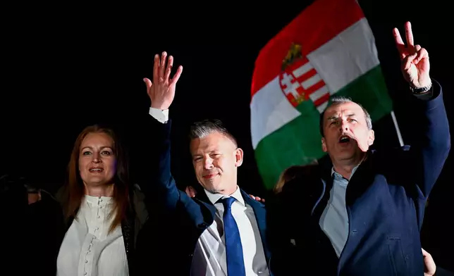 Peter Magyar, leader of the opposition Tisza party, center, celebrates with his party colleagues following the announcement of the partial results of the parliamentary election, in Budapest, Hungary, Sunday, April 12, 2026. (AP Photo/Denes Erdos)