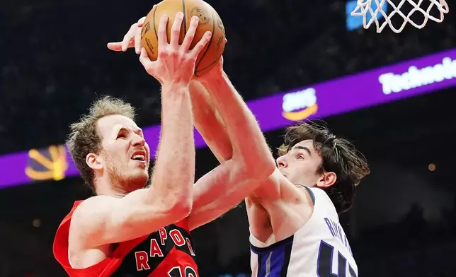 Toronto Raptors' Jakob Poeltl (left) is fouled by Sacramento Kings' Maxime Raynaud (42) during the first half of an NBA basketball game in Toronto, Wednesday, April 1, 2026. (Frank Gunn/The Canadian Press via AP)