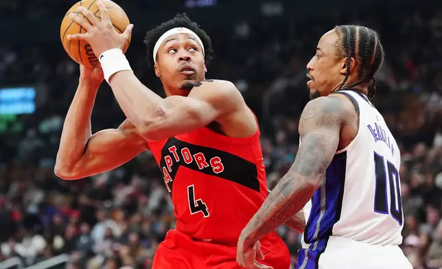 Toronto Raptors' Scottie Barnes (4) protects the ball from Sacramento Kings' DeMar DeRozan (10) during first half of an NBA basketball game in Toronto, Wednesday, April 1, 2026. (Frank Gunn/The Canadian Press via AP)