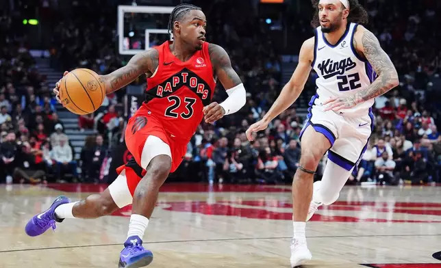 Toronto Raptors' Jamal Shead (23) drives past Sacramento Kings' Devin Carter (22) during the first half of an NBA basketball game in Toronto on Wednesday, April 1, 2026. (Frank Gunn/The Canadian Press via AP)