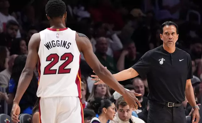 Miami Heat head coach Erik Spoelstra slaps hands with forward Andrew Wiggins (22) during the first half of an NBA basketball game against the Atlanta Hawks, Sunday, April 12, 2026, in Miami. (AP Photo/Rebecca Blackwell)