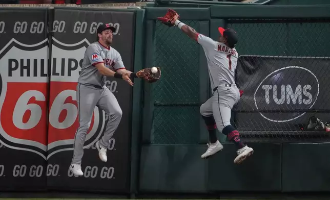 Cleveland Guardians center fielder Daniel Schneemann, left, catches a fly ball by St. Louis Cardinals' Alec Burleson as right fielder Angel Martínez (1) leaps but misses the ball to end the fifth inning of a baseball game Monday, April 13, 2026, in St. Louis. (AP Photo/Jeff Roberson)