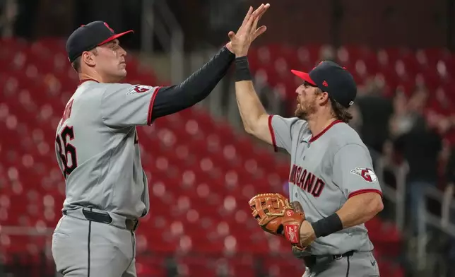 Cleveland Guardians pitcher Cade Smith and Daniel Schneemann celebrate a victory over the St. Louis Cardinals following a baseball game Monday, April 13, 2026, in St. Louis. (AP Photo/Jeff Roberson)