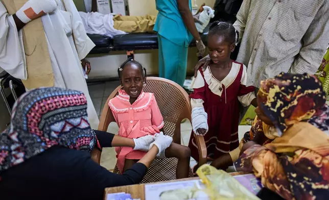 A nurse bandages a young patient injured by an unexploded ordnance blast at Al Nao Hospital in Omdurman, on the outskirts of Khartoum, Saturday, April 18, 2026. (AP Photo/Bernat Armangue)