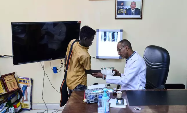 Dr. Jamal Eltaeb checks a patient at Al Nao Hospital in Omdurman, on the outskirts of Khartoum, Saturday, April 18, 2026. (AP Photo/Bernat Armangue)