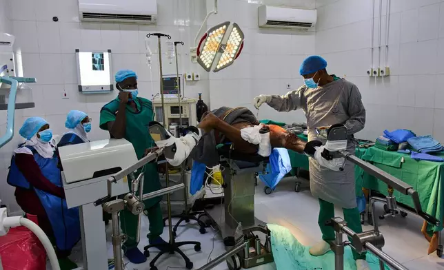 Dr. Jamal Eltaeb operates a patient at Al Nao Hospital in Omdurman, on the outskirts of Khartoum, Monday, April 20, 2026. (AP Photo/Bernat Armangue)
