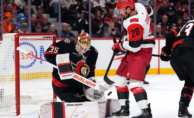 Ottawa Senators goaltender Linus Ullmark (35) looks for the save as Carolina Hurricanes' William Carrier (28) deflects the puck during the third period of an NHL playoff hockey game in Ottawa on Thursday, April 23, 2026. (Sean Kilpatrick/The Canadian Press via AP)