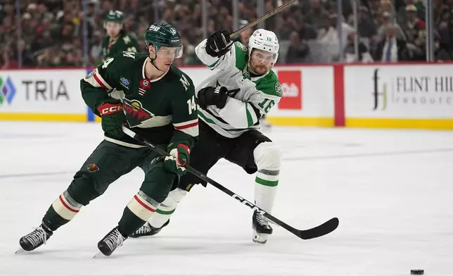 Minnesota Wild center Joel Eriksson Ek (14) and Dallas Stars center Sam Steel (18) battle for the puck during the second period of Game 3 in the first round of the NHL Stanley Cup hockey playoffs Wednesday, April 22, 2026, in St. Paul, Minn. (AP Photo/Abbie Parr)