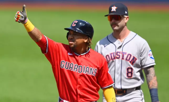 Cleveland Guardians' Jose Ramirez, left, celebrates his single beside Houston Astros first baseman Christian Walker (8) in the first inning of a baseball game in Cleveland, Wednesday, April 22, 2026. (AP Photo/David Richard)