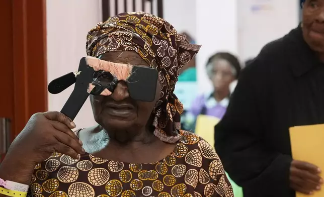Gladys Khoza adjusts an eye testing device during an eye surgery marathon, in Tsakane, South Africa, Saturday, March 28, 2026. (AP Photo/Kayleen Morgan)