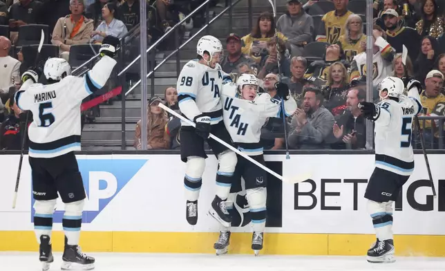 Utah Mammoth defenseman Mikhail Sergachev (98) and center Logan Cooley (92) celebrate after Cooley's goal against the Vegas Golden Knights during the third period in Game 2 of a first-round NHL hockey Stanley Cup playoff series Tuesday, April 21, 2026, in Las Vegas. (AP Photo/Ian Maule)