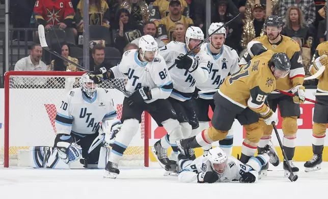 Vegas Golden Knights right wing Mark Stone (61) skates over Utah Mammoth defenseman Nate Schmidt (88) during the first period in Game 2 of a first-round NHL hockey Stanley Cup playoff series Tuesday, April 21, 2026, in Las Vegas. (AP Photo/Ian Maule)