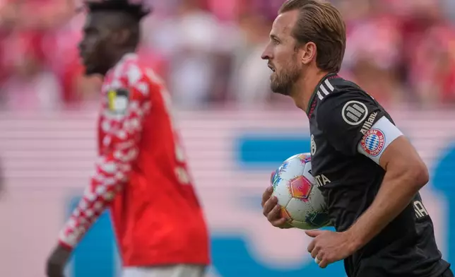 Bayern's Harry Kanecarries the ball back to the center during a Bundeliga soccer match between Mainz and Bayern in Mainz,Germany, Saturday, April 25, 2026. (AP Photo/Michael Probst)