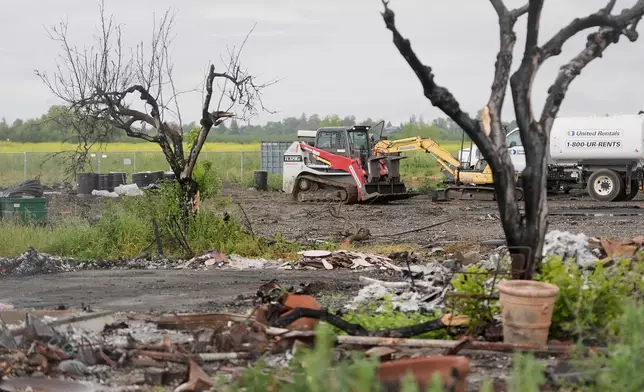 A service vehicle drives near damaged property at the location of a July 1, 2025, fireworks explosion in Esparto, Calif., Friday, April 10, 2026. (AP Photo/Jeff Chiu)