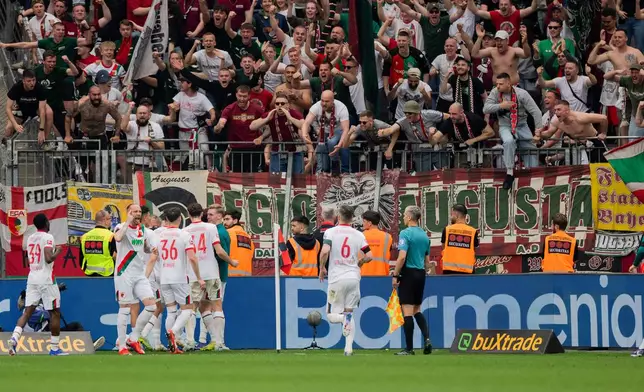 Augsburg players celebrate their goal during their German Bundesliga soccer match against Bayer Leverkusen in Leverkusen, Germany, Saturday, April 18, 2026. (Rolf Vennenbernd/dpa via AP)