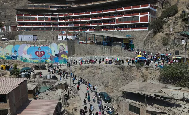 Voters line up outside a polling station during general elections in Lima, Peru, Sunday, April 12, 2026. (AP Photo/Guadalupe Pardo)