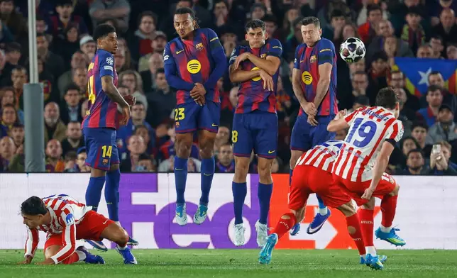 Atletico Madrid's Julian Alvarez, right, takes a free kick during the Champions League quarterfinal first leg soccer match between Barcelona and Atletico Madrid in Barcelona, Spain, Wednesday, April 8, 2026. (AP Photo/Joan Monfort)