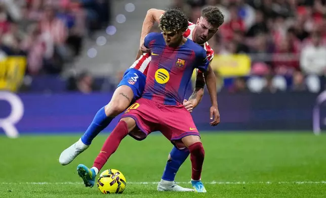 Barcelona's Lamine Yamal, front defends the ball from Atletico Madrid's Matteo Ruggeri during a La Liga soccer match between Atletico Madrid and Barcelona in Madrid, Spain, Saturday, April 4, 2026. (AP Photo/Bernat Armangue)