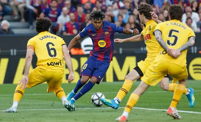 Barcelona's Lamine Yamal, centre, controls the ball during the Spanish La Liga soccer match between Barcelona and Espanyol in Barcelona, Spain, Saturday, April 11, 2026. (AP Photo/Joan Monfort)