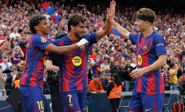 Barcelona's Ferran Torres, centre, celebrates after scoring his side's second goal with Lamine Yamal, left, and Fermin Lopez during the Spanish La Liga soccer match between Barcelona and Espanyol in Barcelona, Spain, Saturday, April 11, 2026. (AP Photo/Joan Monfort)