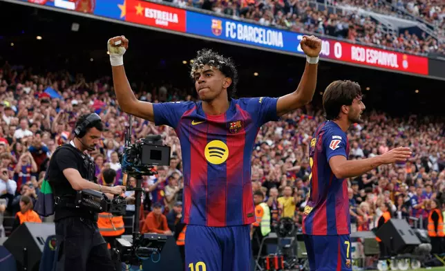 Barcelona's Lamine Yamal celebrates after Ferran Torres, right, scored their side's second goal during the Spanish La Liga soccer match between Barcelona and Espanyol in Barcelona, Spain, Saturday, April 11, 2026. (AP Photo/Joan Monfort)