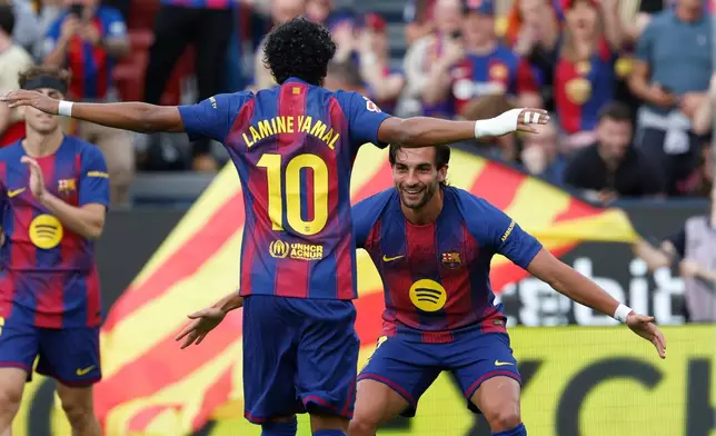 Barcelona's Ferran Torres, right, celebrates after scoring the opening goal with Barcelona's Lamine Yamal during the Spanish La Liga soccer match between Barcelona and Espanyol in Barcelona, Spain, Saturday, April 11, 2026. (AP Photo/Joan Monfort)