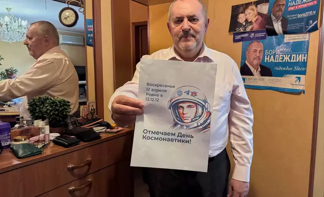 Opposition politician Boris Nadezhdin holds a poster while speaking to journalists, in Moscow, Wednesday, April 1, 2026. (AP Photo)