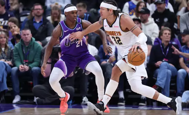 Denver Nuggets forward Aaron Gordon (32) drives with the ball against Utah Jazz guard Bez Mbeng (21) during the first half of an NBA basketball game, Wednesday, April 1, 2026, in Salt Lake City. (AP Photo/Rob Gray)