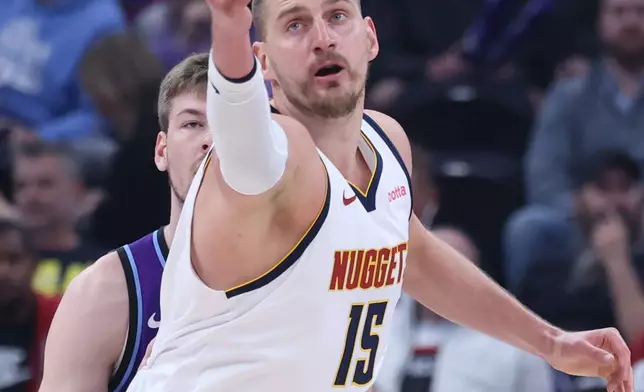 Denver Nuggets center Nikola Jokic reaches for the ball during the first half of an NBA basketball game against the Utah Jazz, Wednesday, April 1, 2026, in Salt Lake City. (AP Photo/Rob Gray)