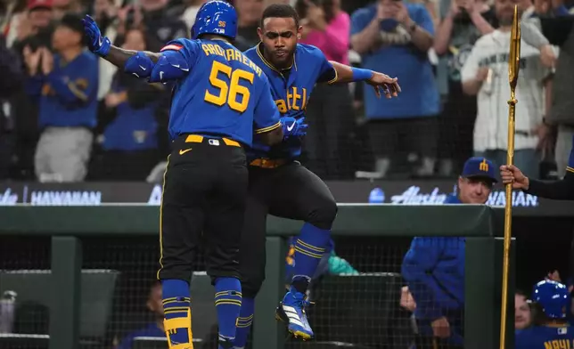 Seattle Mariners' Randy Arozarena (56) celebrates his two-run home run with Julio Rodríguez, facing against the Houston Astros during the fifth inning of a baseball game, Friday, April 10, 2026, in Seattle. (AP Photo/Lindsey Wasson)