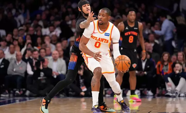 Atlanta Hawks forward Jonathan Kuminga (0) attempts to drive past New York Knicks guard Jordan Clarkson (00) during the first half in Game 2 of a first-round NBA playoffs basketball series, Monday, April 20, 2026, in New York. (AP Photo/Yuki Iwamura)