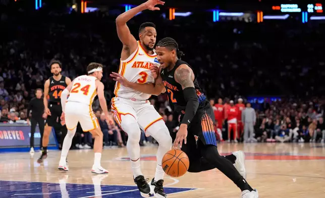 New York Knicks guard Miles McBride (2) drives past Atlanta Hawks guard CJ McCollum (3) during the first half in Game 2 of a first-round NBA playoffs basketball series, Monday, April 20, 2026, in New York. (AP Photo/Yuki Iwamura)