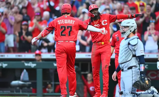 Cincinnati Reds' Sal Stewart, left, celebrates after his three-run home run with teammate Elly de la Cruz, second from left, during the first inning of a baseball game against the Detroit Tigers in Cincinnati, Saturday, April 25, 2026. (AP Photo/Ben Jackson)