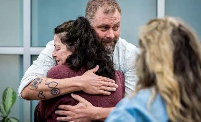 Utah County Sheriff's Deputy Jake Hall, lead detective on the case, looks to other family members as he hugs Tommi Aime, youngest sister of Laura Ann Aime, after announcing that definitive evidence has linked Ted Bundy to Laura's murder at a news conference at the Utah County Sheriff's Office, in Spanish Fork, Utah, Wednesday, April 1, 2026. (Isaac Hale/The Deseret News via AP)