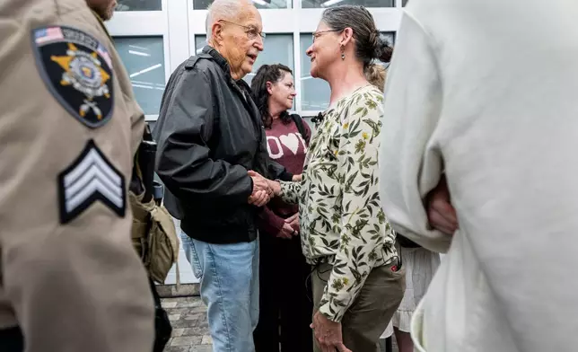 Brent Bullock, center left, who led investigations at the Utah County Attorney's Office around the time of Laura Ann Aime's murder, shakes hands with Michelle Impala, Aime's younger sister, after a news conference at the Utah County Sheriff's Office in Spanish Fork, Utah, Wednesday, April 1, 2026, announcing definitive evidence linking Ted Bundy to Aime's murder. (Isaac Hale/The Deseret News via AP)