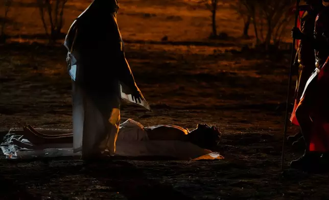 A woman playing the role of Mary stands before David Sanchez, playing the role of Jesus Christ, after he was taken down from the cross during a Way of the Cross reenactment as part of Holy Week celebrations, in Colina, Chile, on Good Friday, April 3, 2026. (AP Photo/Esteban Felix)