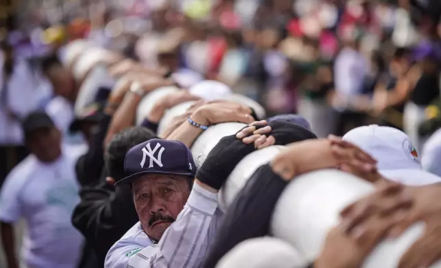Faithful carry a cross to the Tree of Life during a Good Friday procession in the Ciudad Bolivar neighborhood of Bogota, Colombia, Friday, April 3, 2026. (AP Photo/Ivan Valencia)