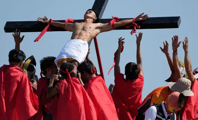 Performers bring down Heron Aquino after he was nailed to the cross during a reenactment of Jesus Christ's sufferings as part of Good Friday rituals in the San Pedro Cutud village, Pampanga province, northern Philippines April 3, 2026. (AP Photo/Aaron Favila)