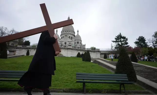 Paris Archbishop Laurent Ulrich, carries the cross during the Way of Cross ceremony to mark Good Friday, outside the Sacre Coeur basilica, in Paris, Friday, April 3, 2026 . (AP Photo/Thibault Camus)