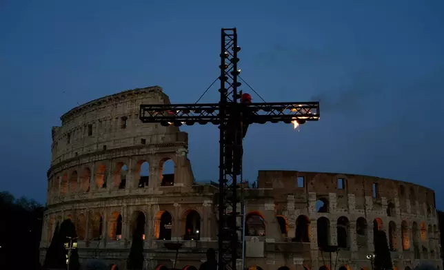 A giant cross is set up in front of the Colosseum in Rome ahead of the Via Crucis, the torchlit Catholic Good Friday Stations of the Cross procession attended by Pope Leo XIV, Friday, April 3, 2026, which symbolically retraces Jesus Christ's steps to his crucifixion on Calvary in Jerusalem. (AP Photo/Gregorio Borgia)