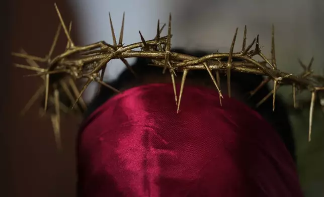 A hooded penitent, wearing prickly cactus thorns on his head, prepares to walk in a Good Friday procession during Holy Week in Atlixco, Mexico, Friday, April 3, 2026. (AP Photo/Fernando Llano)