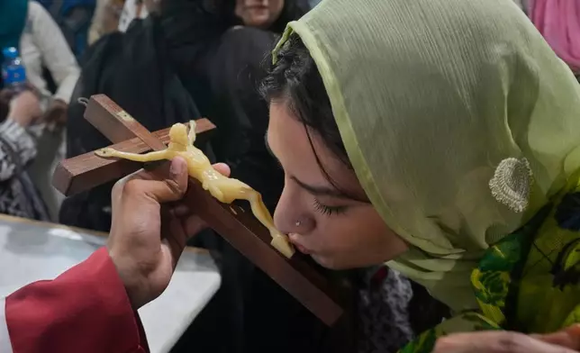 A Christian woman kisses a Jesus Christ cross during Good Friday service at Sacred Heart Cathedral, in Lahore, Pakistan, Friday, April 3, 2026. (AP Photo/K.M. Chaudary)
